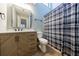 Well-lit bathroom features an updated vanity with modern hardware and a shower with plaid curtain at 1002 Creatwood Se Cir, Smyrna, GA 30080
