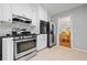 Well-equipped kitchen with stainless steel appliances, white cabinets, and view into adjacent dining area at 1809 Claron Ave, Conley, GA 30288
