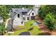Aerial view of the home's backyard featuring a pool with a waterfall, a manicured lawn, and mature trees at 819 Loridans Dr, Atlanta, GA 30342