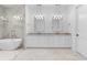 Modern bathroom featuring double sinks, a soaking tub, walk-in shower, and mosaic tile floors at 819 Loridans Dr, Atlanta, GA 30342