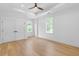 Spacious primary bedroom featuring a tray ceiling, ceiling fan, hardwood floors, and multiple windows at 819 Loridans Dr, Atlanta, GA 30342