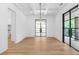 Bright dining room with hardwood floors, modern lighting, and a stunning black metal frame front door at 819 Loridans Dr, Atlanta, GA 30342