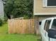 Fenced backyard with lawn and the rear of a split-level home at , Roswell, GA 30076