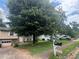 Split-level home with a large tree in the front yard and a driveway leading to an attached garage at , Roswell, GA 30076
