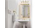 Elegant powder room featuring stylish fixtures, lighting, and a pedestal sink with gold accents at 2556 Oakwood Se Trce, Smyrna, GA 30080