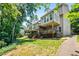 Back view of townhomes with backyard patios surrounded by lush trees at 2556 Oakwood Se Trce, Smyrna, GA 30080