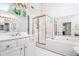 Bright main bathroom features a frameless glass shower, soaking tub, and vanity with dual sinks at 2556 Oakwood Se Trce, Smyrna, GA 30080