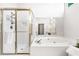 Bright main bathroom features a frameless glass shower and soaking tub with gold trim at 2556 Oakwood Se Trce, Smyrna, GA 30080