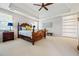 Bright main bedroom features a tray ceiling, large windows, neutral carpet, and a carved wood bed and bedside table at 2556 Oakwood Se Trce, Smyrna, GA 30080