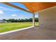 A covered brick back porch with a wood paneled ceiling, overlooking a spacious, grassy backyard at 3284 Hall Rd, Dacula, GA 30019