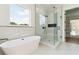 Luxurious bathroom with a freestanding tub, glass-enclosed shower, and a large window with backyard views at 3284 Hall Rd, Dacula, GA 30019