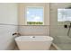 Bright bathroom showcasing a luxurious soaking tub and a view to the outdoors at 3284 Hall Rd, Dacula, GA 30019