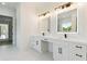 Elegant Primary bathroom featuring dual vanities with modern light fixtures, countertop space, and ample storage at 3284 Hall Rd, Dacula, GA 30019