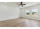 Bright bedroom with hardwood floors, ceiling fan, and a view of the green lawn and house at 3284 Hall Rd, Dacula, GA 30019