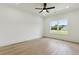 Bedroom with ceiling fan, hardwood floors and a view to the neighborhood at 3284 Hall Rd, Dacula, GA 30019