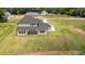 Aerial shot shows the rear exterior of a new two-story home with a covered patio and expansive green yard at 3284 Hall Rd, Dacula, GA 30019