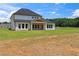 Two-story home with a covered patio overlooking a lush green lawn at 3284 Hall Rd, Dacula, GA 30019