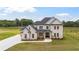 Beautifully designed two-story home with a manicured lawn on a sunny day at 3284 Hall Rd, Dacula, GA 30019