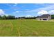 Back exterior view of modern home on large lot, with expansive green field at 3284 Hall Rd, Dacula, GA 30019
