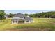 Rear view captures a new two-story home with a covered patio, spacious backyard, and well-kept lawn at 3284 Hall Rd, Dacula, GA 30019