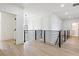 Bright hallway with modern railings, hardwood floors, and decorative overhead lighting at 3284 Hall Rd, Dacula, GA 30019