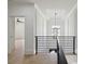 Hallway with modern railing, chandelier, hardwood floors, and intricate ceiling details at 3284 Hall Rd, Dacula, GA 30019