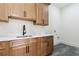 Laundry room with white marble counters, upper and lower wood cabinets, and dark tiled floor at 3284 Hall Rd, Dacula, GA 30019