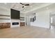 A spacious living room with coffered ceilings, fireplace with modern shelving, and staircase leading to the second floor at 3284 Hall Rd, Dacula, GA 30019