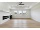 Bright living room with hardwood floors, a modern fireplace, and three large windows at 3284 Hall Rd, Dacula, GA 30019