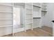 Open walk-in closet with custom shelving and hardwood floors at 3284 Hall Rd, Dacula, GA 30019