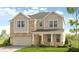 Two-story home featuring a brick and vinyl exterior, attached two-car garage, a front porch, and manicured lawn at 82 Sheryl Way, Loganville, GA 30052