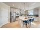 Open kitchen featuring stainless steel appliances, white cabinets, and a center island with barstool seating and pendant lights at 82 Sheryl Way, Loganville, GA 30052