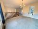 Bright living room with elegant chandelier, neutral carpeting, and stairway at 1047 Martin Heights Dr, Lawrenceville, GA 30044
