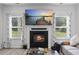 Fireplace with a TV hung above and surrounded by bright light from the large windows at 2260 Cedar Place Ct, Snellville, GA 30078