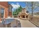 Stone outdoor kitchen with a grill and wooden dining table on a deck at 866 Coopers Ridge Sw Path, Grayson, GA 30017