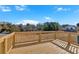 Wooden back deck overlooking expansive lawn and treeline with a sunny blue sky at 19 Bridgemill Dr, Douglasville, GA 30134