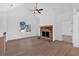 Living room with stone fireplace and wood mantle, ceiling fan, and view into kitchen at 19 Bridgemill Dr, Douglasville, GA 30134