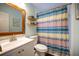 Charming bathroom featuring a bright vanity, decorative shelves, and a colorful shower curtain at 2232 Dunseath Ave # 407, Atlanta, GA 30318