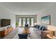 Bright living room featuring a comfortable gray sofa, a modern TV, and glass doors to a balcony at 3650 Ashford Dunwoody Rd, Ne, #923, Atlanta, GA 30319