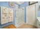 Bright bathroom featuring a glass-enclosed shower, soft blue walls, and decorative towels at 3802 Abbott Ln # 14, Powder Springs, GA 30127