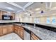 Wet bar with wooden cabinets, stainless steel dishwasher, and granite countertop at 3871 River Mansion Dr, Peachtree Corners, GA 30096