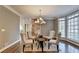 Charming dining area open to the staircase, offering hardwood floors and a modern chandelier for stylish entertaining at 3871 River Mansion Dr, Peachtree Corners, GA 30096