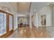 Spacious foyer with hardwood floors, decorative glass door, and dining area in the background at 3871 River Mansion Dr, Peachtree Corners, GA 30096