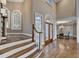 Grand foyer with staircase, hardwood floors, and decorative glass door, enhancing the entrance's appeal at 3871 River Mansion Dr, Peachtree Corners, GA 30096