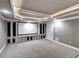 Home theater with built-in cabinets, projector screen, carpeted floor, and adjacent door at 3871 River Mansion Dr, Peachtree Corners, GA 30096