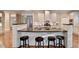 Modern kitchen featuring sleek white cabinetry, a large island with stools, and stainless steel appliances at 3871 River Mansion Dr, Peachtree Corners, GA 30096