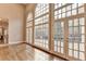 Bright living room with three windows, hardwood floors, and access to the outdoor deck at 3871 River Mansion Dr, Peachtree Corners, GA 30096
