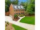 Beautiful brick two-story home featuring mature trees, a well-manicured lawn, and a three-car garage at 4250 Green Ridge Ne Dr, Marietta, GA 30062
