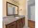 Bathroom with a framed mirror above the wooden vanity with marble counter at 2945 Cardinal Lake Cir, Duluth, GA 30096