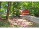 A detached garage with a roll-up door and concrete driveway in a wooded setting at 2945 Cardinal Lake Cir, Duluth, GA 30096